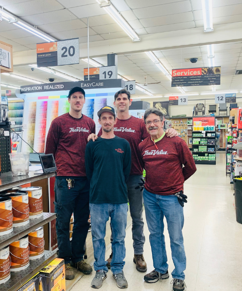 Four Fiore Rental employees standing together in front of the paint department