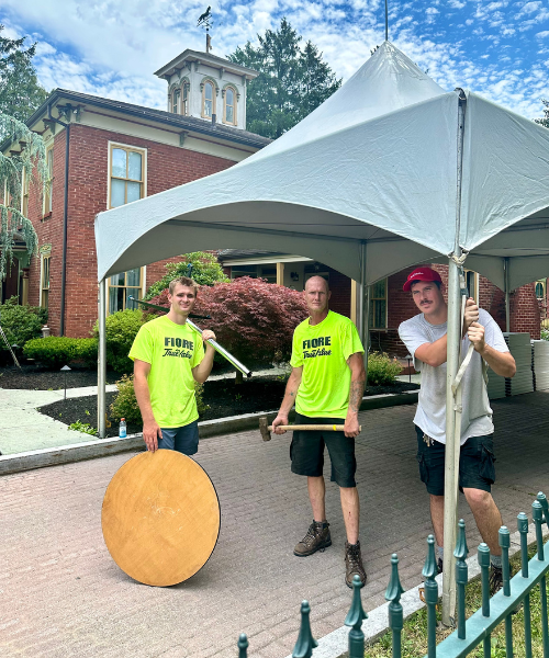 Three Fiore Rental staff standing in front / inside of a tent