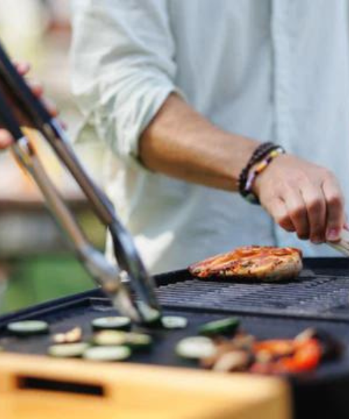 BBQ grill being sed to cook chicken and vegetables