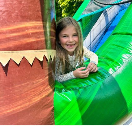 Bounce House RentalsGirl smiling while sitting on a bounce house